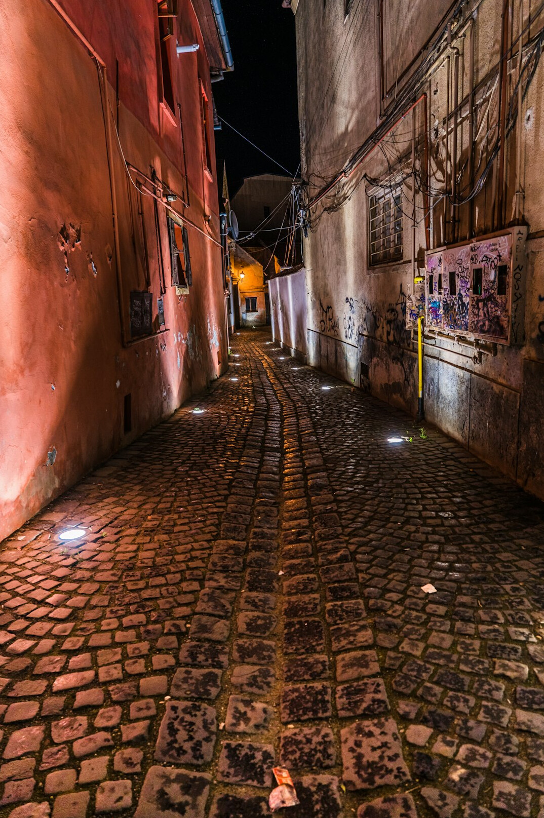 Old cobblestone street at dusk with warm lamp light